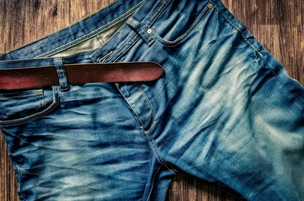 Detalhe de jeans azul com cinto de couro em estilo vintage — Fotografia de Stock