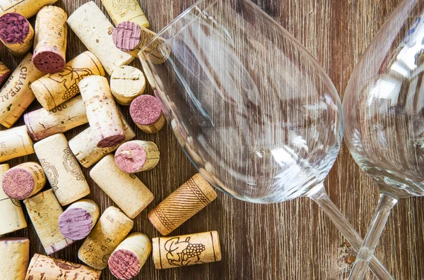 Detal, kieliszki do wina i korki na drewnianym stole — Zdjęcie stockowe