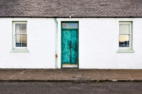 Groene deur en twee vensters op witte muur huis — Stockfoto