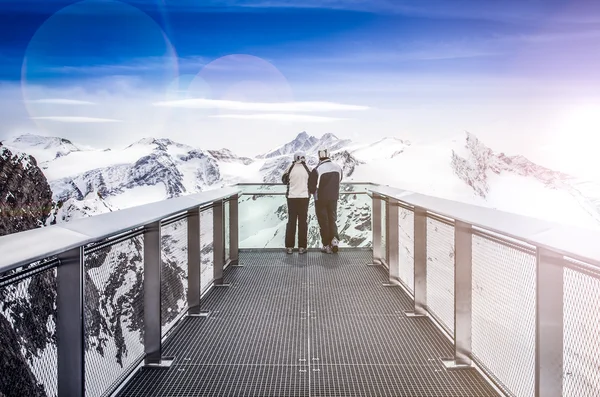 Two people looking at Alps mountains from viewpoint platform — Stock Photo, Image