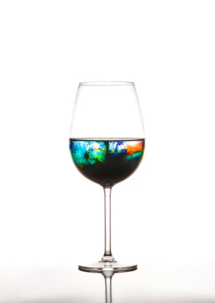 Beyaz arka plan üzerinde renkli su ile cam — Stok fotoğraf