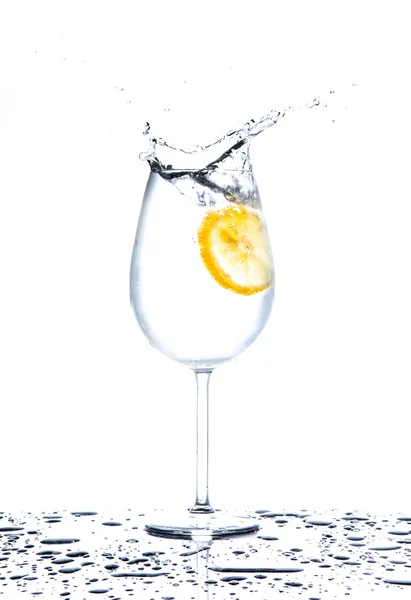 Λεμόνι εκτινάξεις σε ποτήρι νερό σε άσπρο φόντο — Φωτογραφία Αρχείου