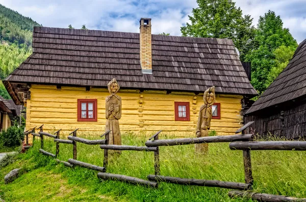 Vue sur maison de village traditionnelle et statues boisées — Photo