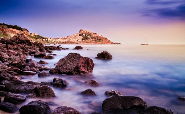 Costa del océano con pueblo al fondo al amanecer — Foto de Stock