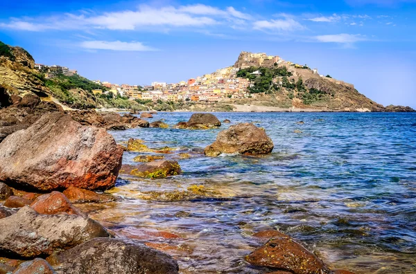 Oceaan rotsachtige kustlijn met kleurrijke stad castelsardo, Italië — Stockfoto