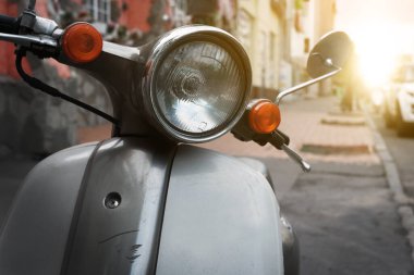 Eski moda bir scooter Avrupa 'da bir caddede park halinde duruyor. İki tekerlekli araç kiralama konsepti.