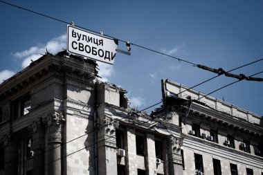 A road sign with the name of Svoboda Street against the backdrop of the Kharkiv Regional State Administration destroyed on Svobody Square in Kharkiv by a Russian rocket. War of Russia against Ukraine.