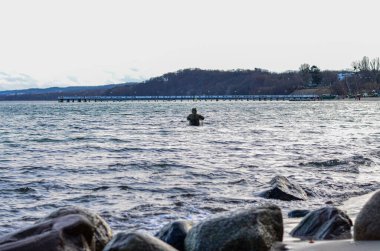 Adam Baltık Denizi 'nin kayalık kıyısında Orlowo, Gdynia, Polonya' da balık tutuyor.