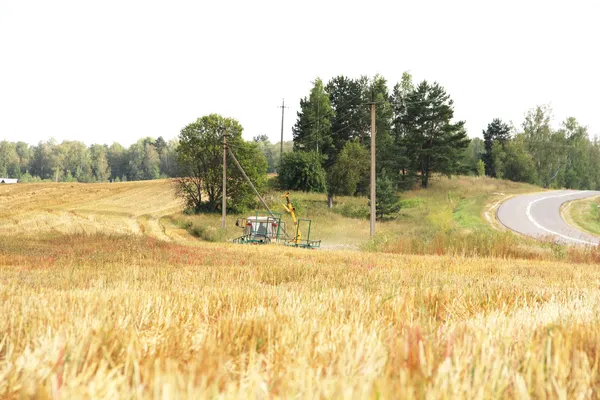 Tractor con heno en el campo en el día de verano — Foto de Stock