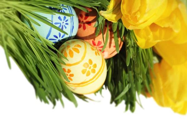 Easter eggs in grass with tulips — Stock Photo, Image