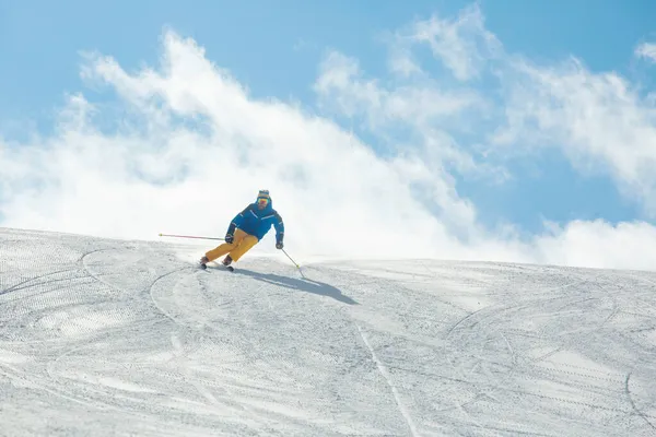 Sciatore Maschile Abiti Blu Gialli Pista Con Montagne Sullo Sfondo — Foto Stock