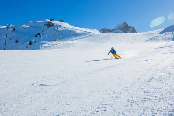 Sciatore Maschile Abiti Blu Gialli Pista Con Montagne Sullo Sfondo — Foto Stock