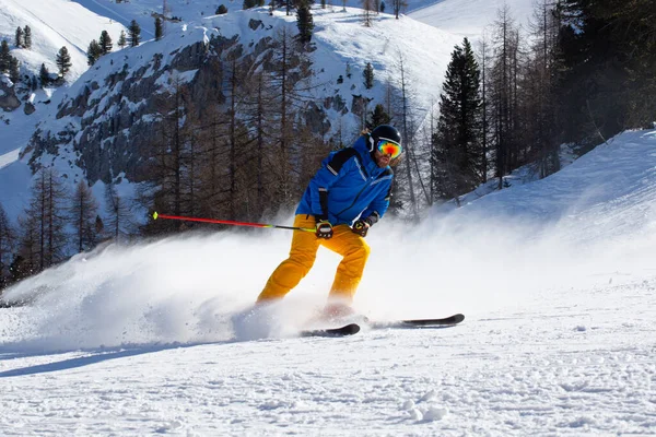 Sciatore Maschile Abiti Blu Gialli Pista Con Montagne Sullo Sfondo — Foto Stock