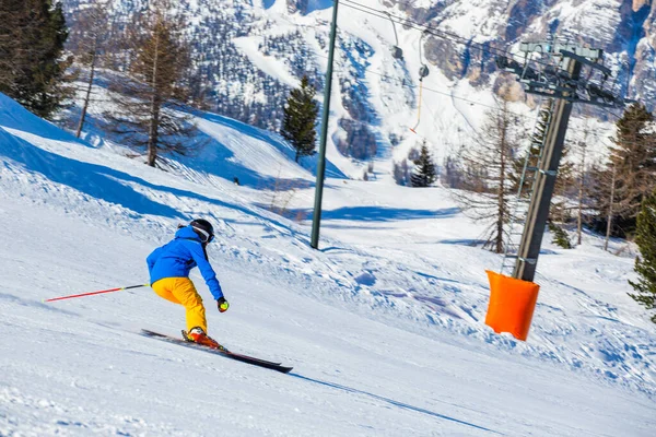 Sciatore Maschile Abiti Blu Gialli Pista Con Montagne Sullo Sfondo — Foto Stock