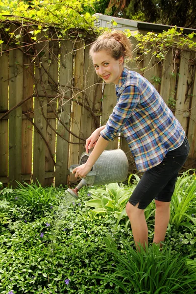 Teen watering flowers — Stock Photo, Image