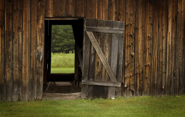 Stodoła drzwi otwarte na zielony krajobraz — Zdjęcie stockowe
