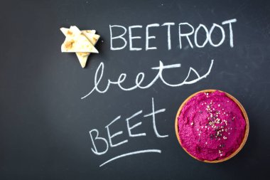 Siyah zemin üzerinde pita olan pancar kökü humusunun en üst görüntüsü. Tebeşirle daha iyi ayak, pancar ve pancar yazılıyor.