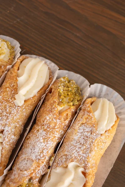 Top view of cannoli freshly display in nice paper on a wooden background