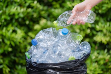 Siyah çöp torbalarındaki plastik şişeler geri dönüşüm için alınmayı bekliyor..