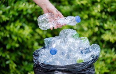 Siyah çöp torbalarındaki plastik şişeler geri dönüşüm için alınmayı bekliyor..