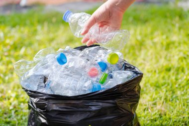 Siyah çöp torbalarındaki plastik şişeler geri dönüşüm için alınmayı bekliyor..