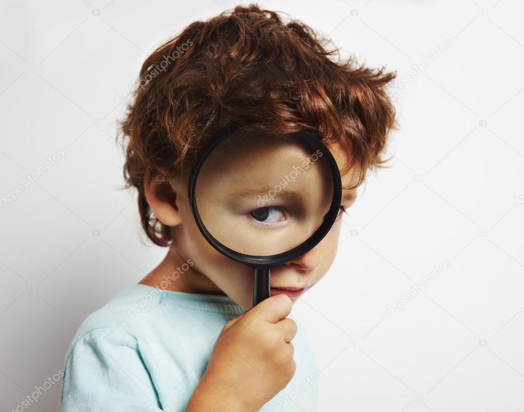 Boy looking through a magnifying glass