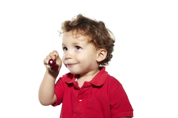 Vrolijke jonge jongen met cherry — Stockfoto