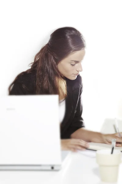 Mujer joven en el trabajo con un ordenador portátil —  Fotos de Stock