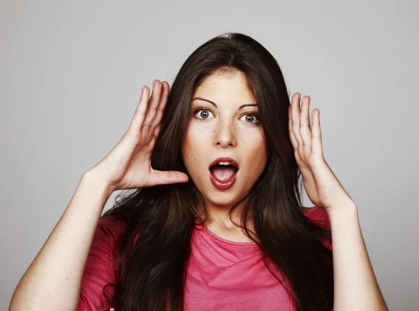 Portrait of beautiful young woman looking scared on grey background — Stock Photo, Image