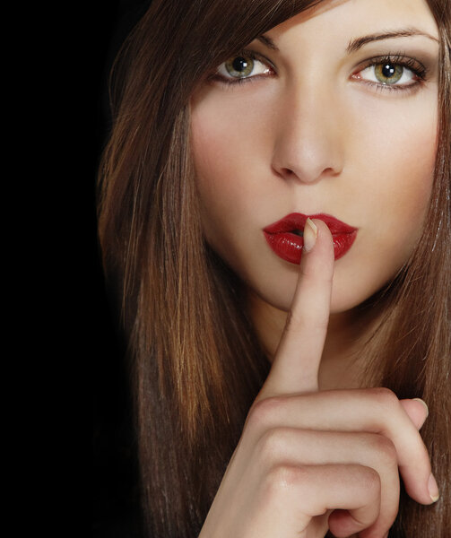 Portrait of attractive young girl with finger on lips, brown long hair, iso