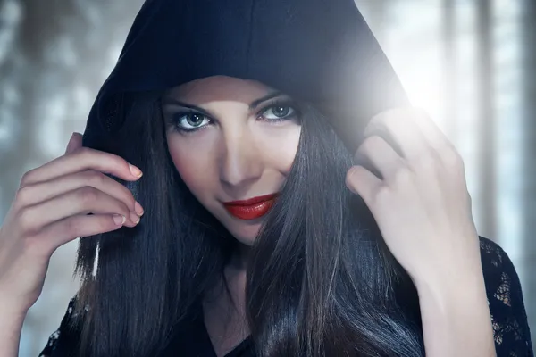 Portrait of a young woman in hood over forest backgroung — Stock Photo, Image