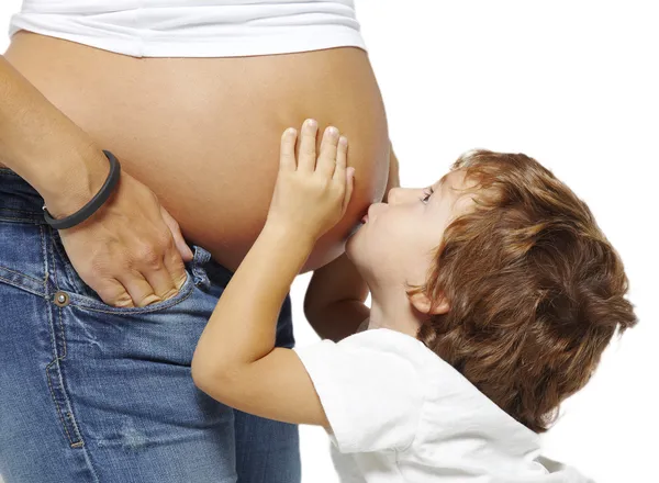 妊娠中の母親の腹にキス少年 — ストック写真