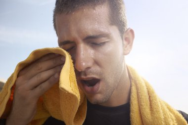 Sweating young man with a towel