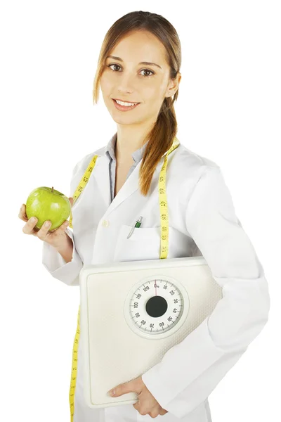 Nutritionist innehar ett grönt äpple och vikt skala — Stockfoto