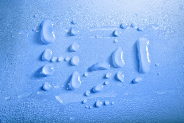 Gotas de agua H2O sobre fondo azul — Foto de Stock