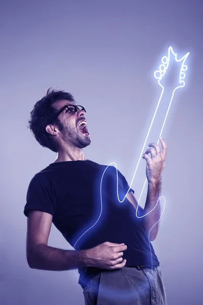 Young man playing imaginary guitar and squealing Royalty Free Stock Images