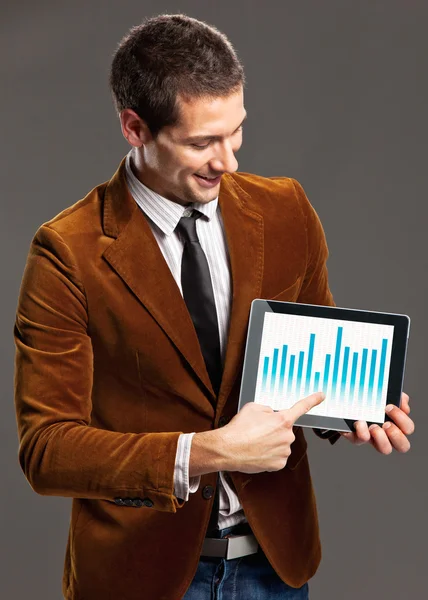 Young businessman touching a tablet screen with graphics. — Stock Photo, Image