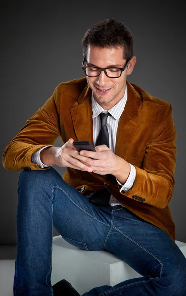 Young interesting businessman touching smartphone — Stock Photo, Image