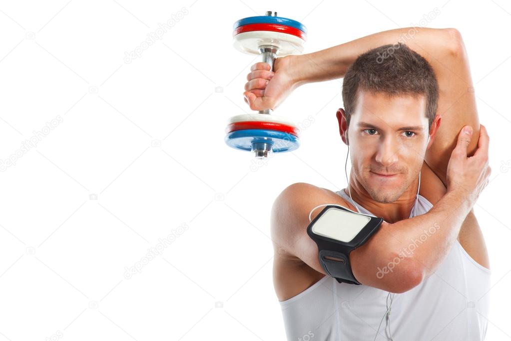 Young man lifting weight and listening to portable music