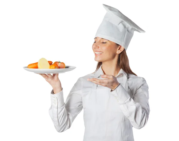 Mulher cozinheira feliz mostrando um prato com legumes — Fotografia de Stock