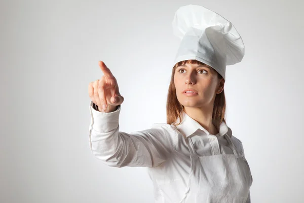 Kobieta kucharz wskazując puste puste miejsce na białym tle — Zdjęcie stockowe