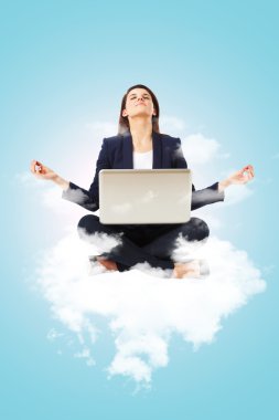 dizüstü bilgisayar ile yoga lotus pozisyonda oturan genç iş kadını