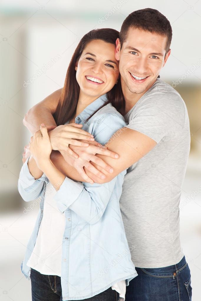 Cheerful young couple standing at home