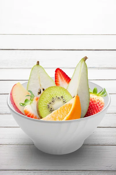 Frutas frescas em uma tigela branca isolada — Fotografia de Stock