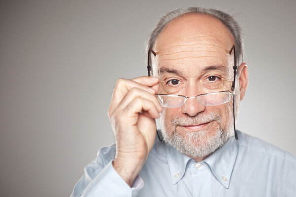 Portrait of old man taking glasses