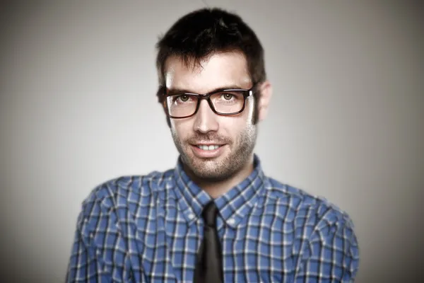 Porträtt av en normal pojke med glasögon på grå bakgrund. — Stockfoto