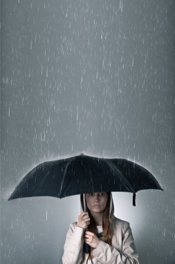 Young woman under an umbrella during rainfall