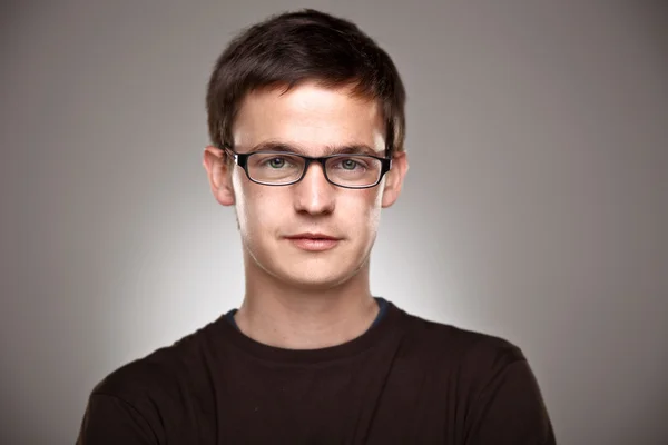 Retrato de un niño normal con gafas de borde sobre un fondo gris — Foto de Stock