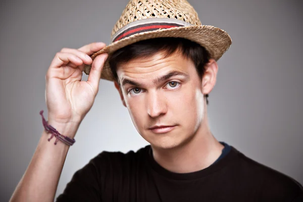 Portrait of a normal boy subject a straw hat on a grey background — Stock Photo, Image