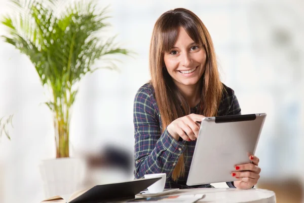 Attractive young woman with a tablet in the office Stock Image